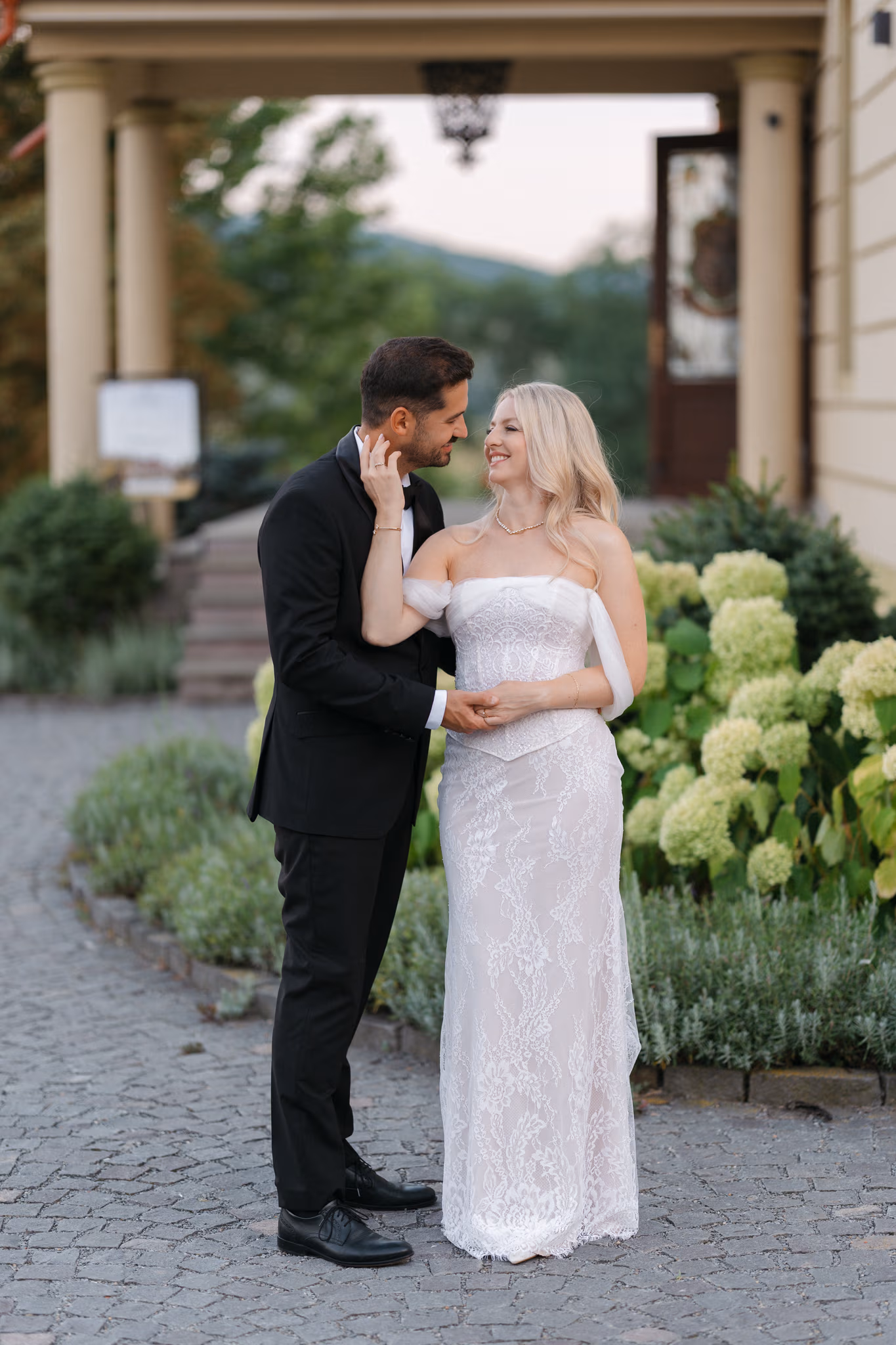Cuplu îmbrățișat lângă hortensii albe conac istoric